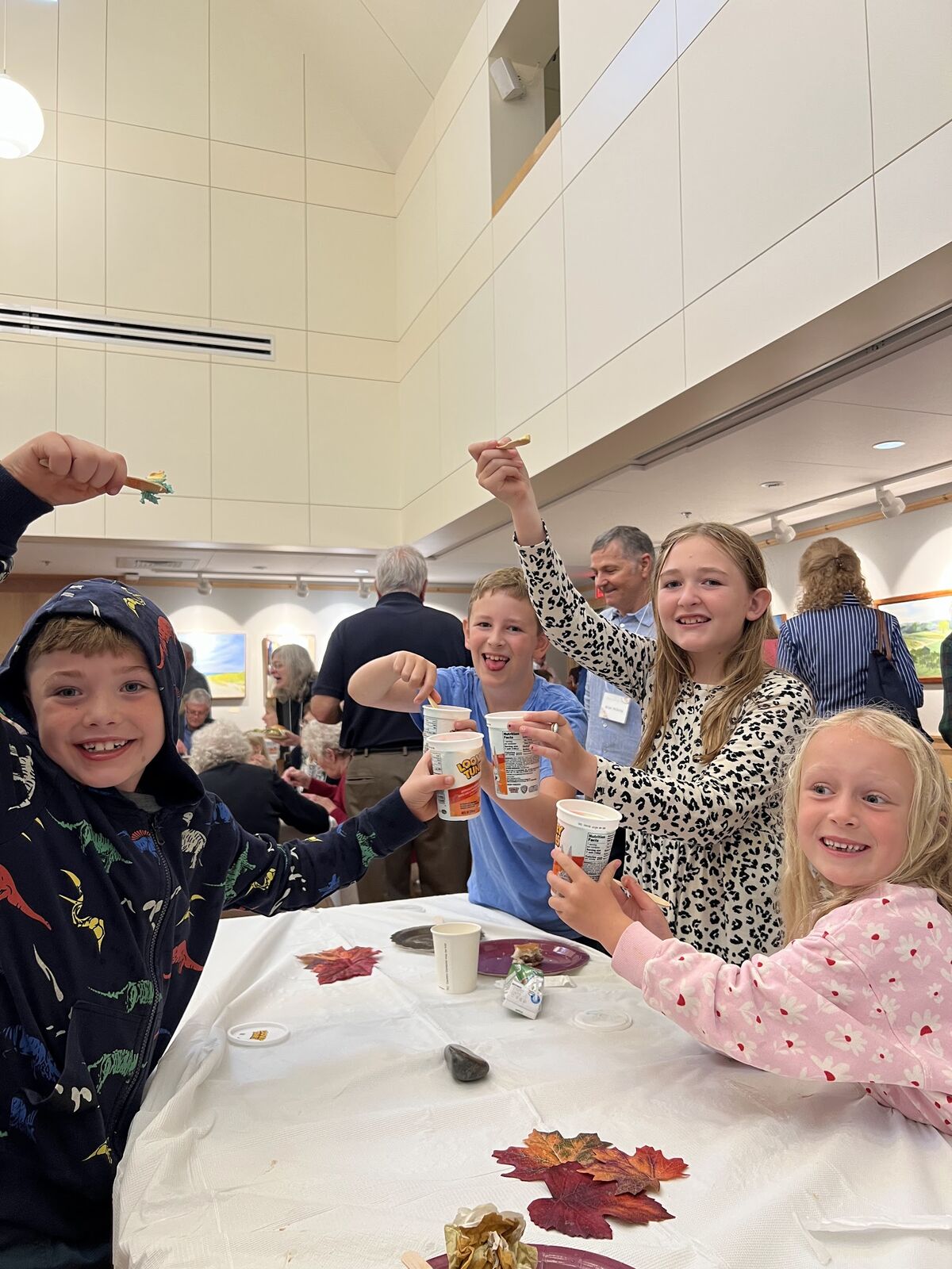 Children laughing and raising their cups at a parish gathering